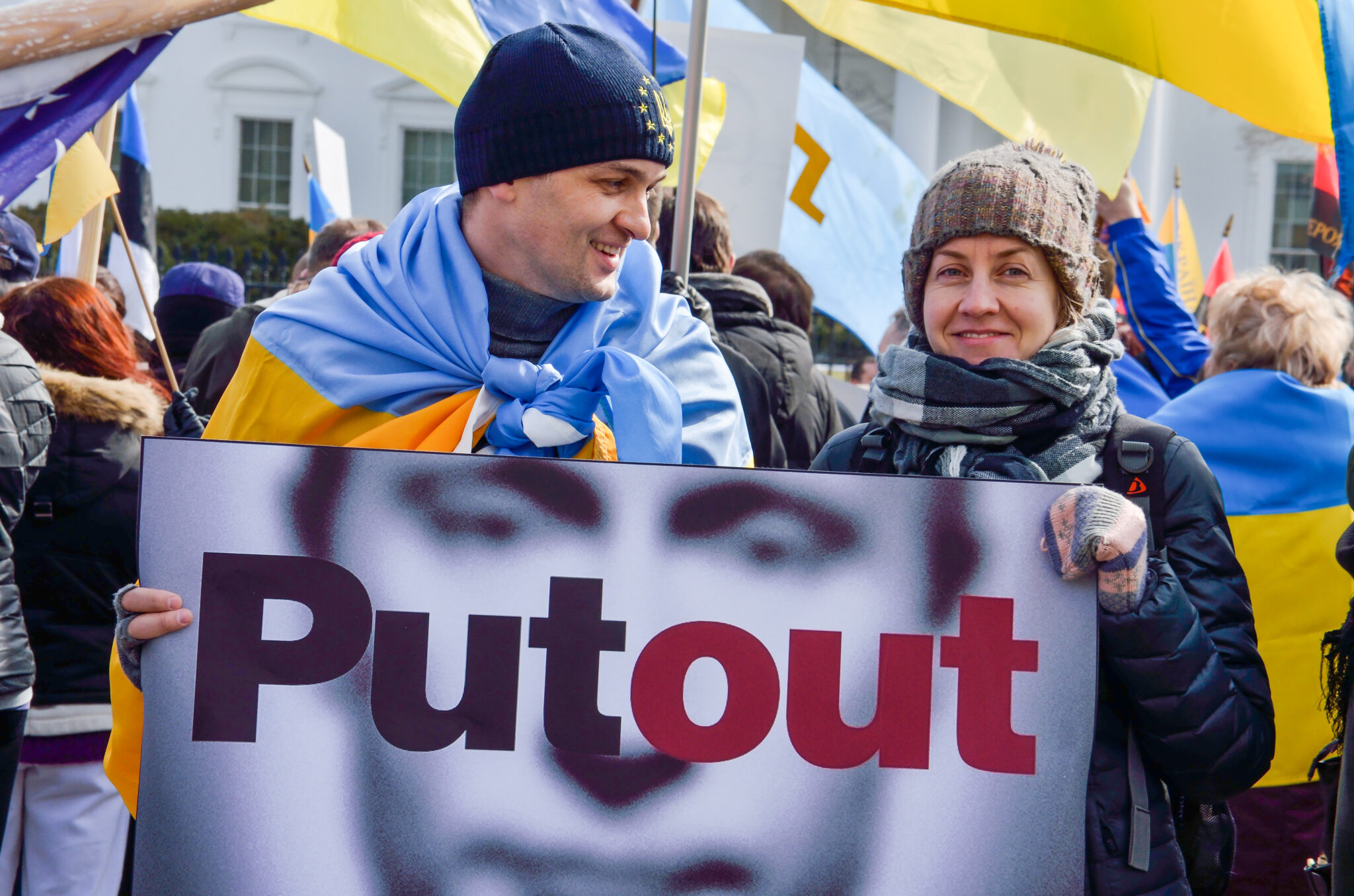 Man and woman holding Vladimir Putin sign during Ukrainian protest